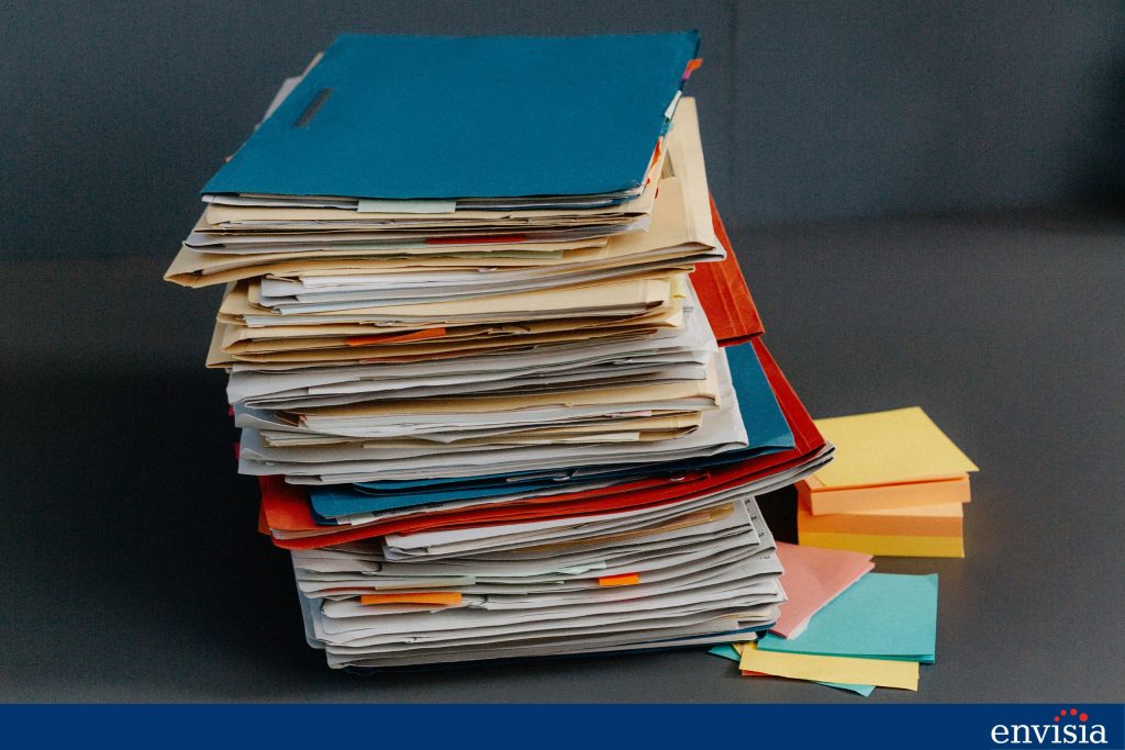 Stack of paperwork symbolizing resource-intensive challenges of 360-degree feedback systems.